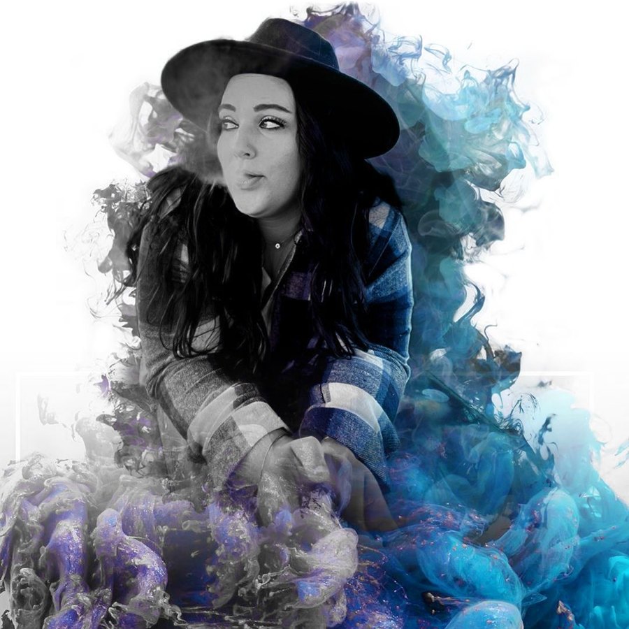 Bek of Lit 'n' Lavish in a black wide-brim hat, exhaling smoke surrounded by blue and violet smoke art